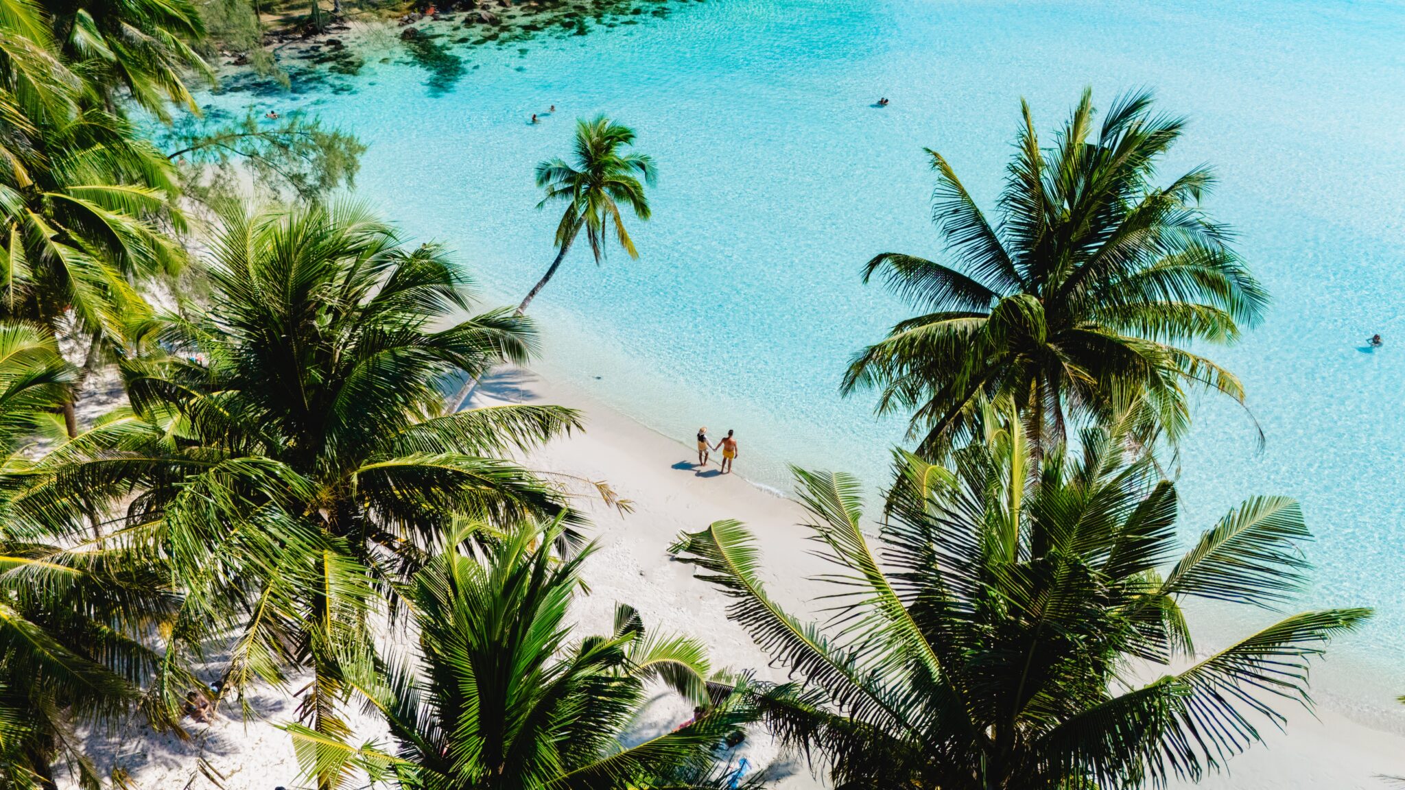 Two,People,Stroll,Along,The,Soft,White,Sand,Of,A